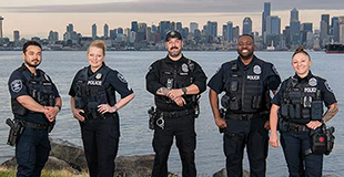 Officers stand in front of Elliot Bay with downtown Seattle in the background