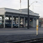 The pergola is painted white and cars are parked underneath.  The viaduct can be seen on the right of the photo. 